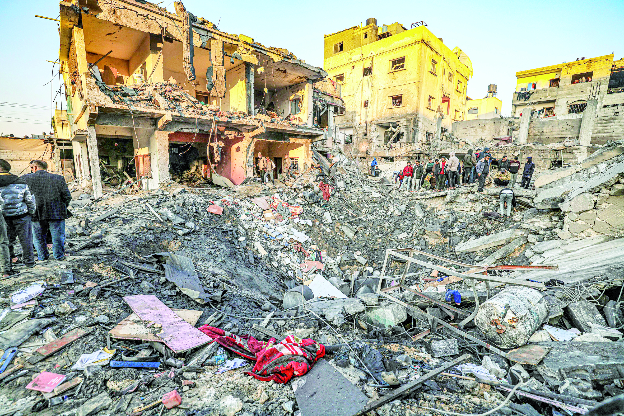 فلسطينيون يتفقدون الدمار الذي خلفه القصف الإسرائيلي على رفح (أ ف ب) 