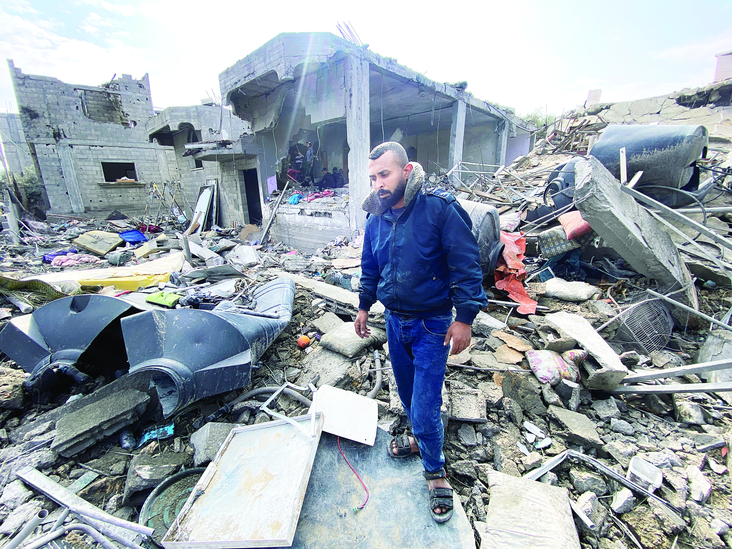  فلسطيني فقد أربعة من أطفاله وزوجته يقف بين الأنقاض في مخيم المغازي (رويترز)  