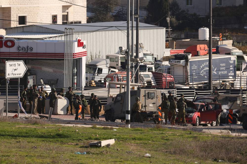 القوات الإسرائيلية تحاصر سيارة قيل إن فلسطينياً استخدمها لدهس الجنود عند مدخل مخيم الفوار (أ ف ب)