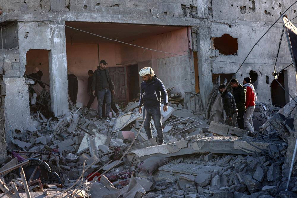 فلسطينيون يتفقدون الأضرار التي لحقت بالقصف الإسرائيلي على رفح (أ ف ب)