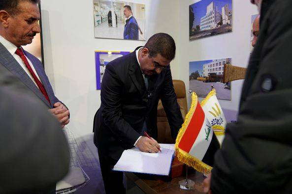 الغريري خلال تدوينه كلمة في سجل الشركة العامة لتصنيع الحبوب 