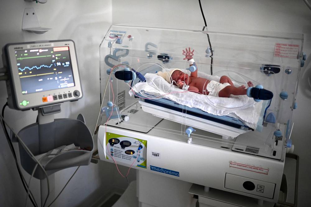 (FILES) A newborn baby lies in an incubator moments after birth at the maternity ward of a hospital in Paris on June 29, 2022. France had an estimated population of 68.4 million by January 1, 2024, representing a further year-on-year increase of 0.3 percent, limited by a marked drop in the birth rate, the INSEE national statistics bureau of France reported on January 16, 2024. In 2023, 678,000 babies were born in France, 6.6 percent fewer than the previous year, the lowest number of births in any year since 1946. Over the same period, there were 631,000 deaths, down 6.5 percent on 2022, a year marked by the consequences of the Covid-19 pandemic and episodes of extreme heat. (Photo by Christophe ARCHAMBAULT / AFP)