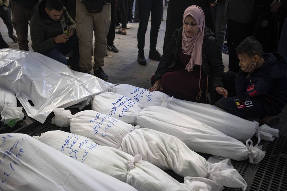Palestinians mourn their relatives killed in the Israeli bombardment of the Gaza Strip, outside a morgue in Rafah, southern Gaza, Thursday, Jan. 18, 2024. (AP Photo/Fatima Shbair)
