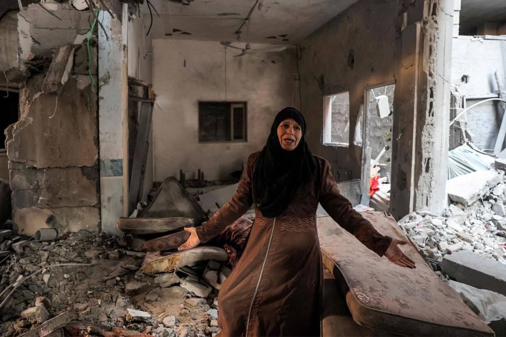 فلسطينية تستغيث بعدما دمر القصف الإسرائيلي منزلها في غزة (أ ف ب)