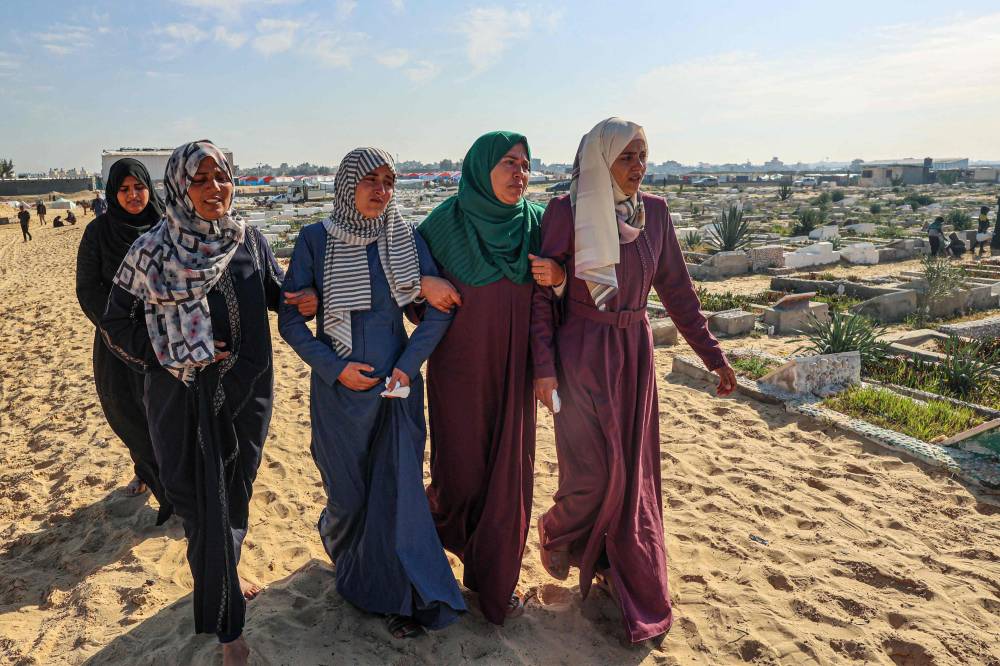 فلسطينيات يبكين أحباءهن الذين قتلوا خلال الغارات الإسرائيلية في مقبرة برفح
