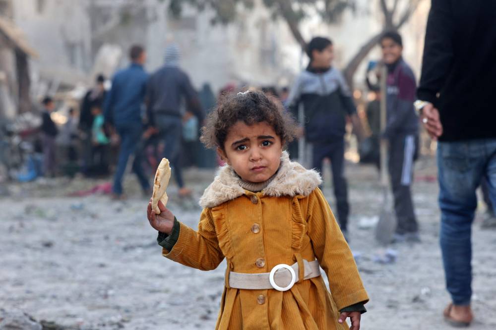  طفلة فلسطينية تأكل قطعة من الخبز في رفح (ا ف ب)