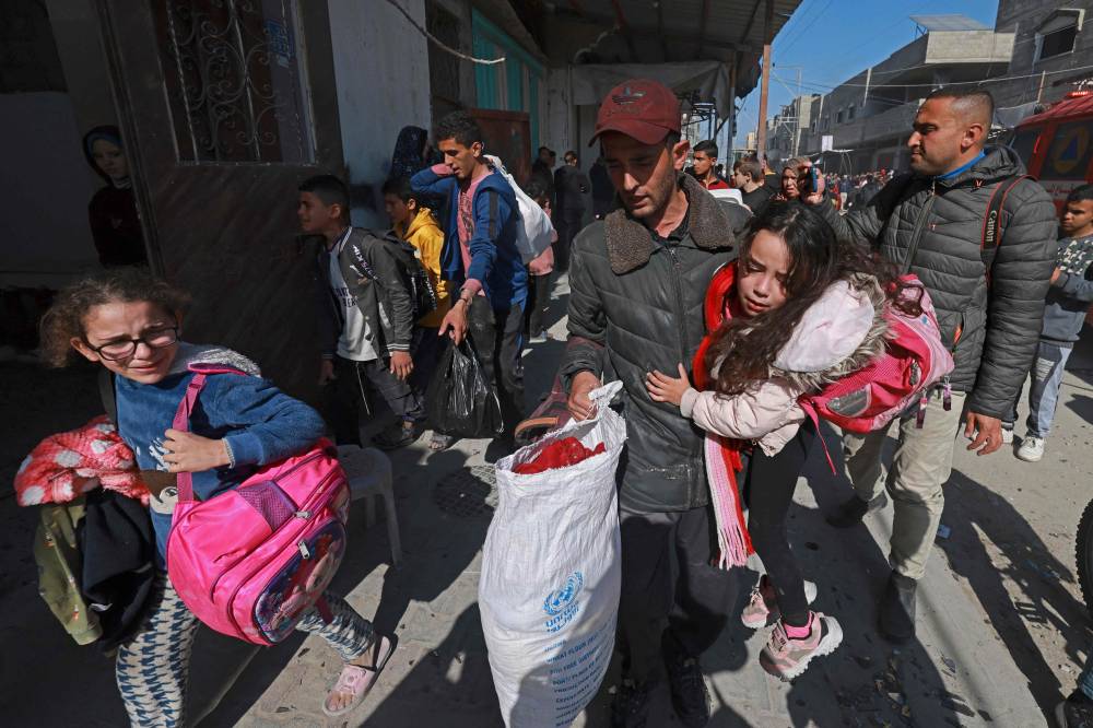 فلسطينيون يفرون من منازلهم مع ممتلكاتهم بعد القصف الإسرائيلي على رفح (أ ف ب) 
