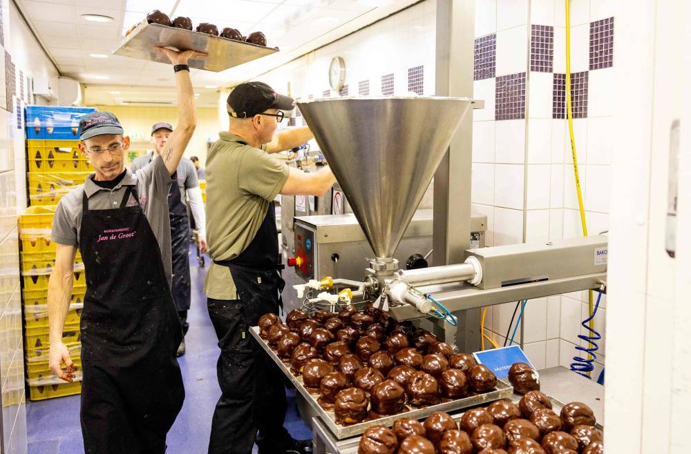 عمال يصنعون «كرة الشوكولاتة» داخل مخبز في هولندا (أ ف ب)