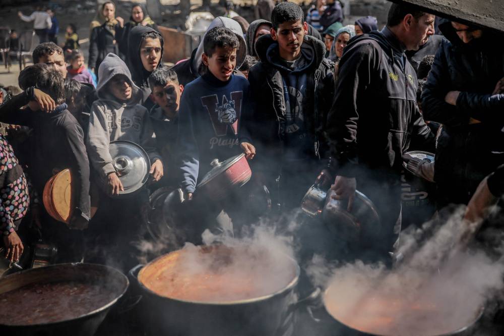 فلسطينيون خلال تسلم وجبات غذائية في بيت لاهيا 