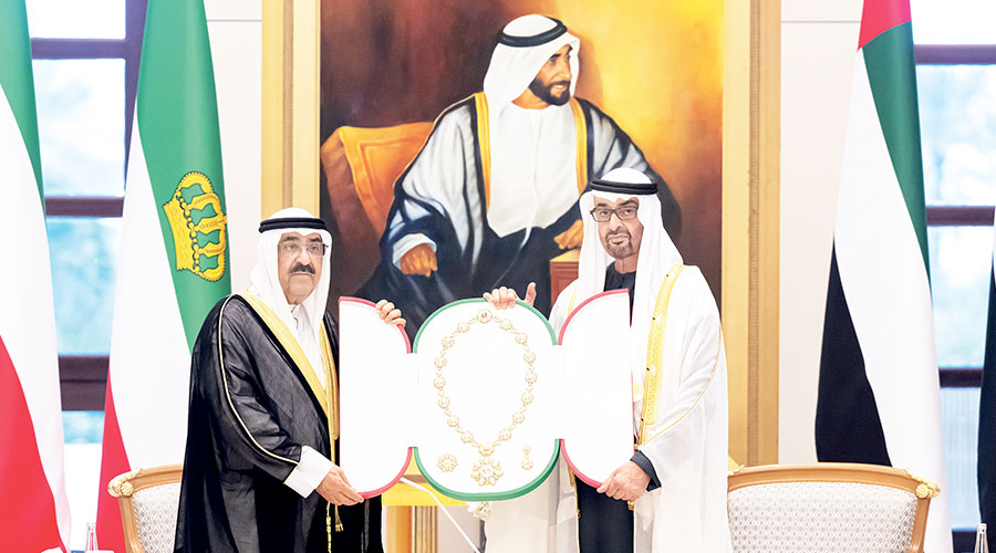 محمد بن زايد خلال منحه مشعل الأحمد وسام زايد