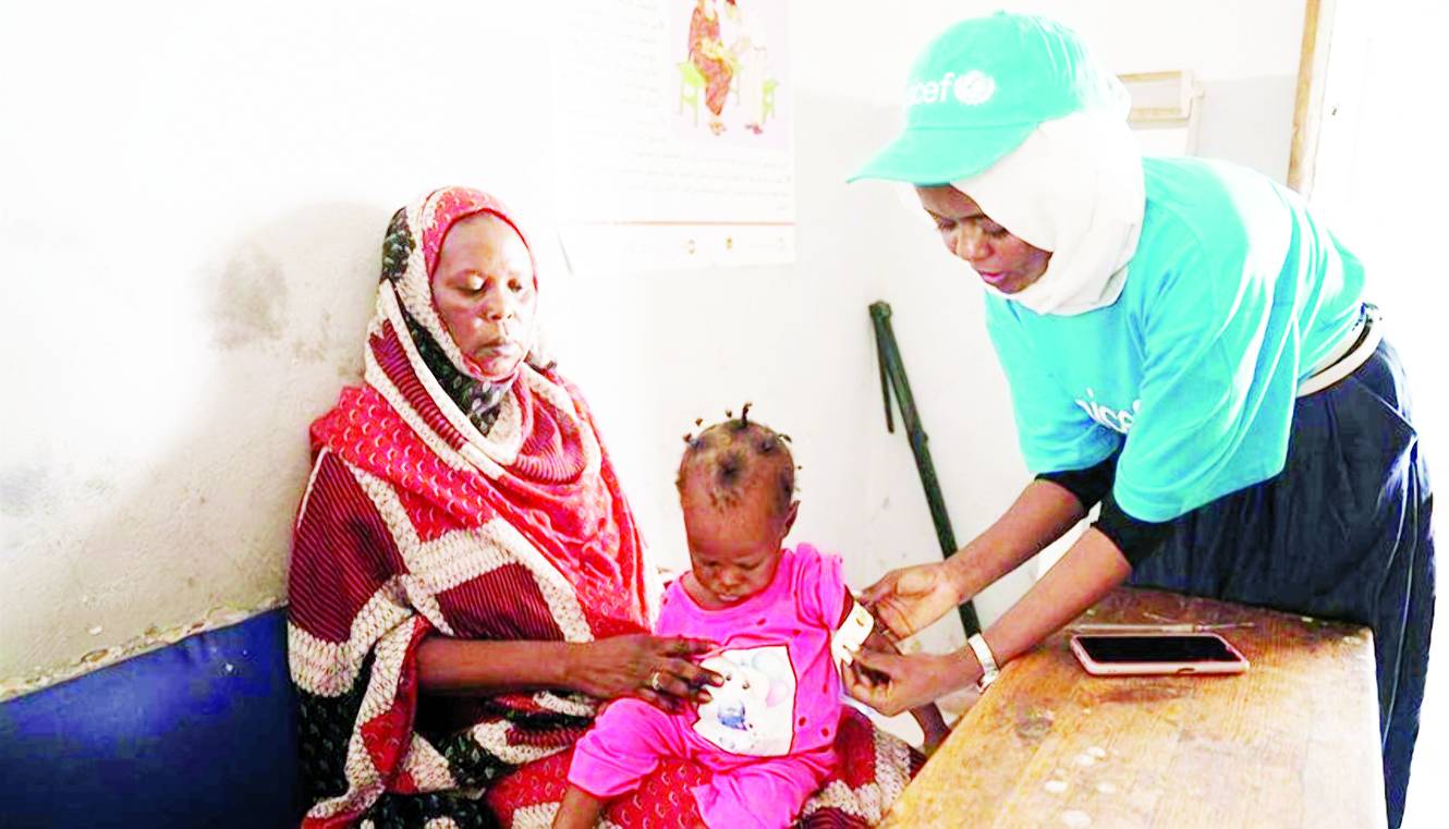 عاملة أممية تحقن طفلاً مصاباً بسوء التغذية (ارشيفية)