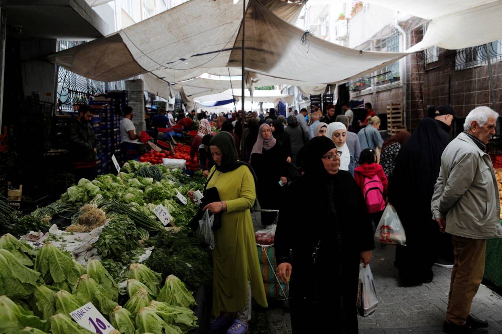 متسوقون بسوق للخضار في إسطنبول (رويترز)