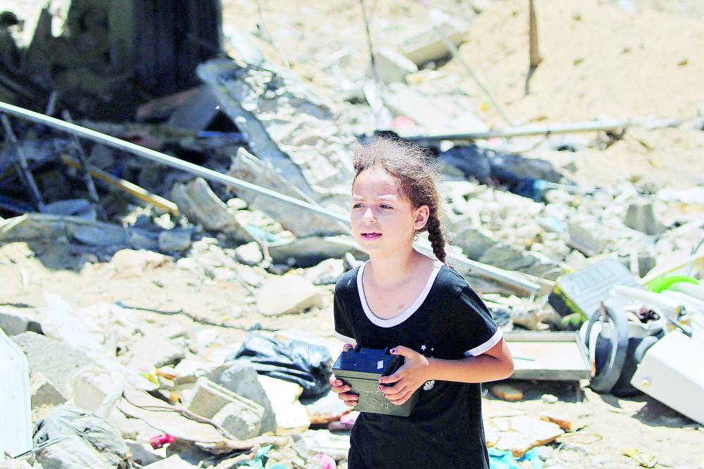 فتاة فلسطينية تسير بالقرب من أنقاض المباني المدمرة في القصف الإسرائيلي على خان يونس 