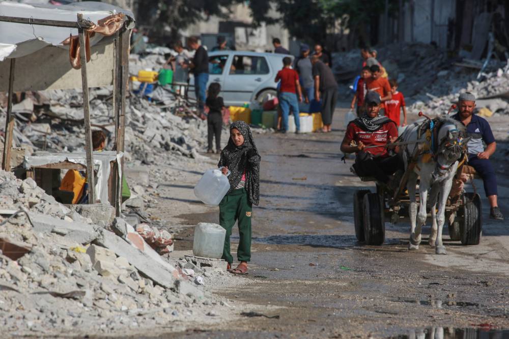 فلسطينيون يصطفون لملء حاويات بالمياه في مدينة خان يونس بجنوب قطاع غزة (أ ف ب)