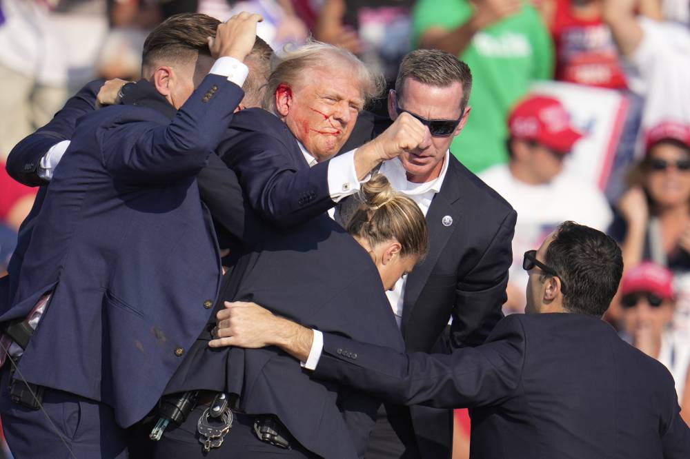 ترامب يلوح بقبضته لأنصاره بعد نجاته من إطلاق النار (أ ب)