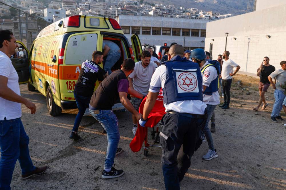 المسعفون ينقلون الضحايا من موقع الحادث (أ ف ب)