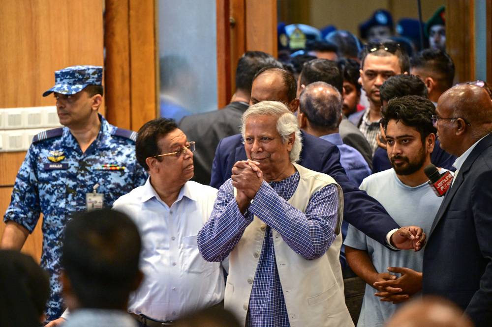 يونس يرحب بالصحفيين عند وصوله دكا (أ ف ب)