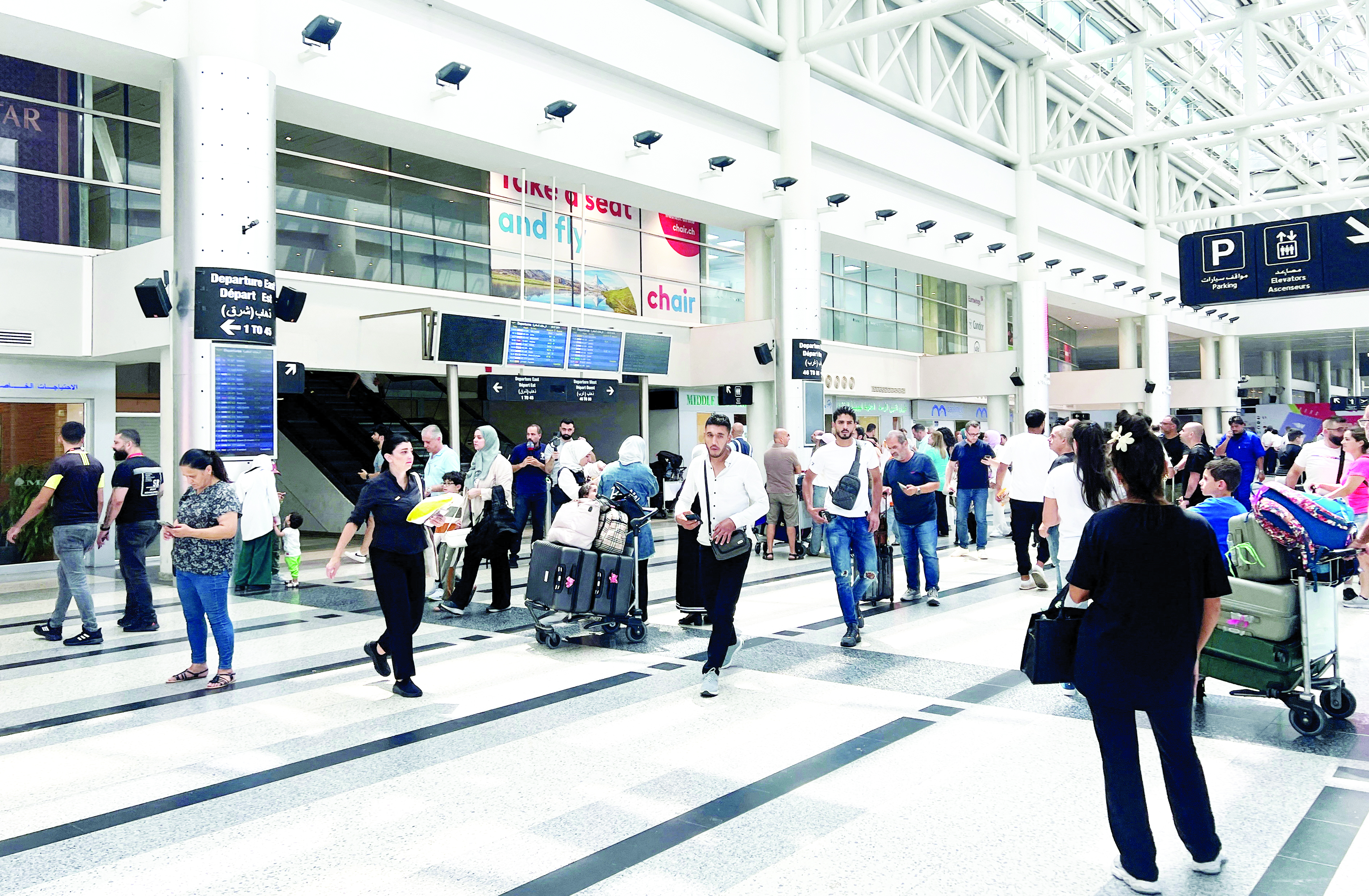 أشخاص يقفون في مطار رفيق الحريري الدولي في بيروت (رويترز)
