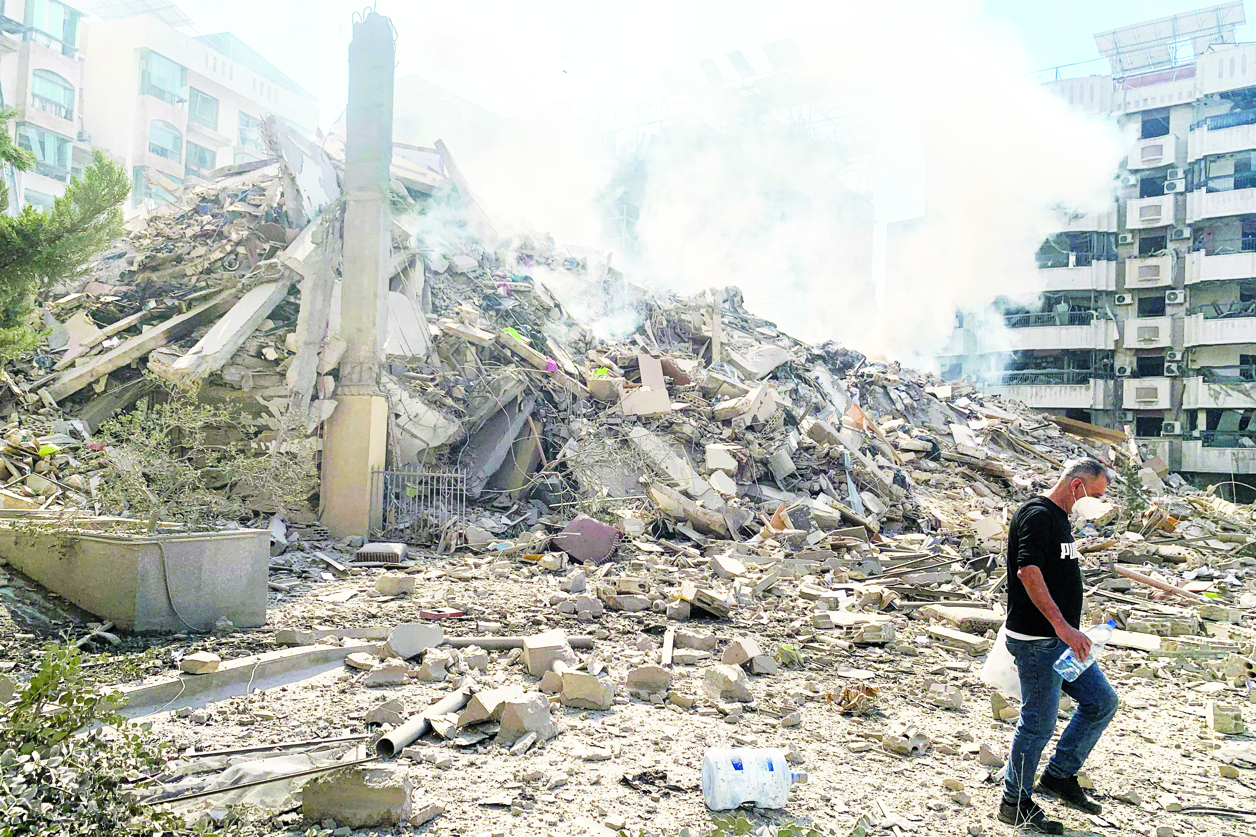 لبناني يسير بجوار مبنى مدمر جراء غارة إسرائيلية على الضاحية الجنوبية (ا ف ب)