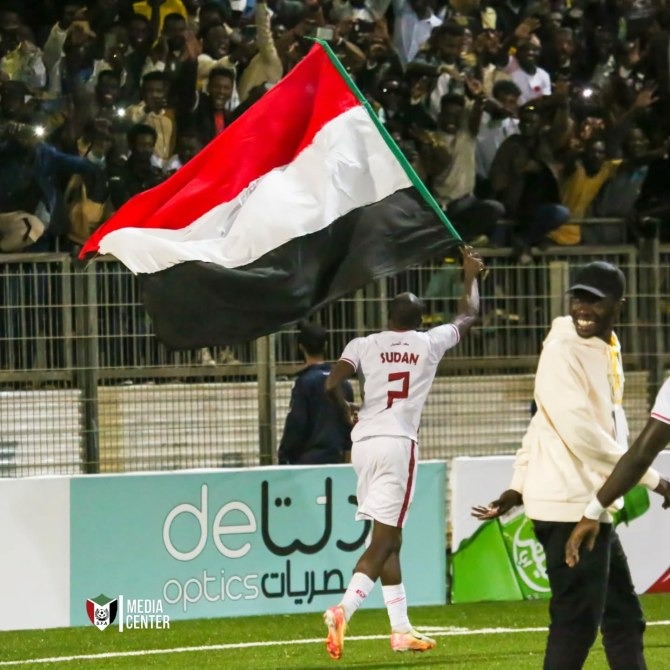 لاعب يحمل علم السودان أمام المشجعين