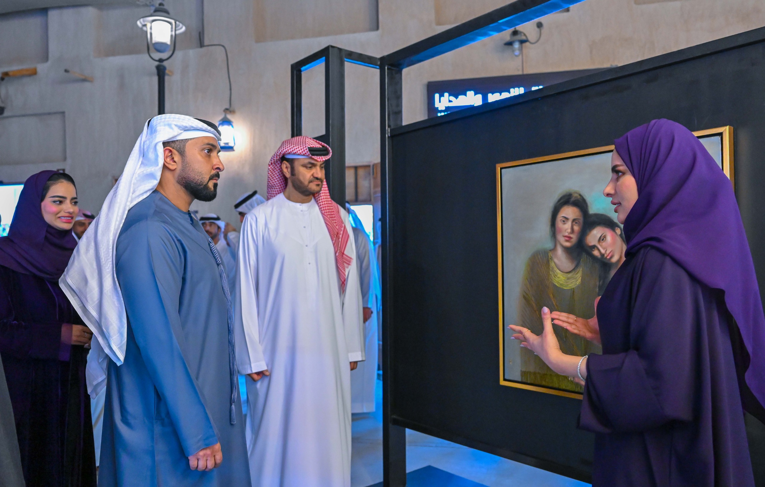 عبد العزيز بن حميد يستمع لشرح مشاركة بعمل فني