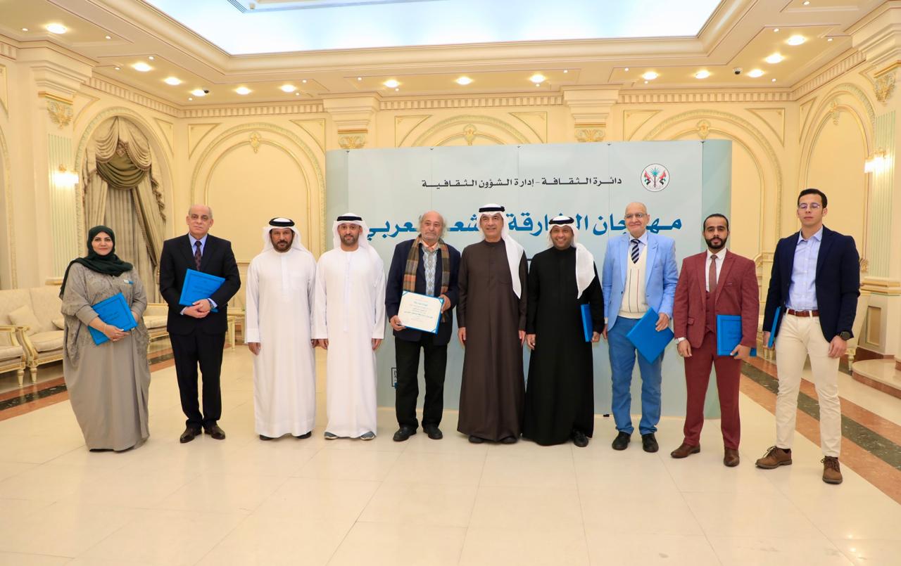عبد الله العويس، ومحمد القصير، ومحمد البريكي يتوسطون الشعراء المشاركين في الأمسية