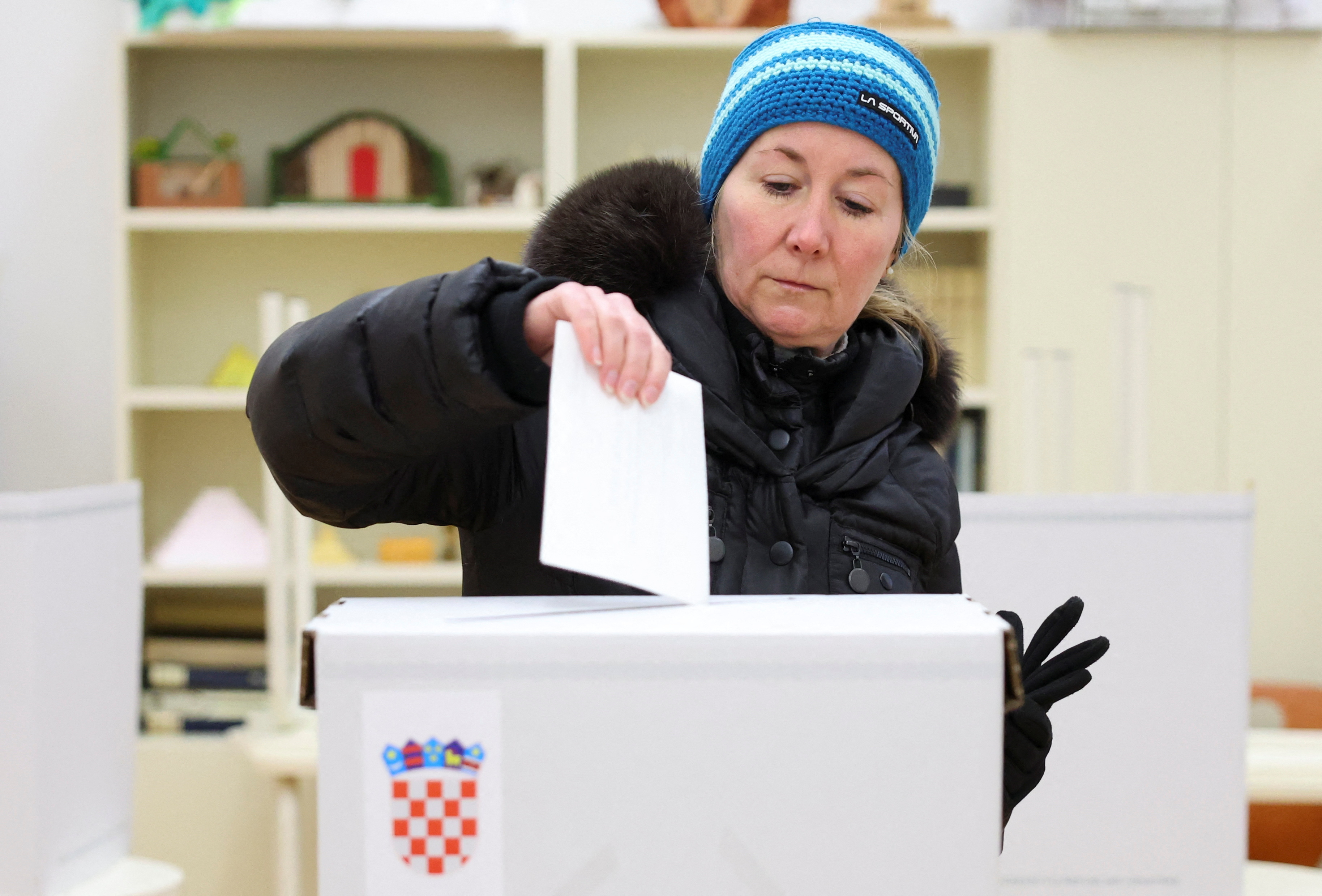 A woman votes at a polling station during the second round of the presidential election in Zagreb, Croatia, January 12, 2025. REUTERS/Antonio Bronic