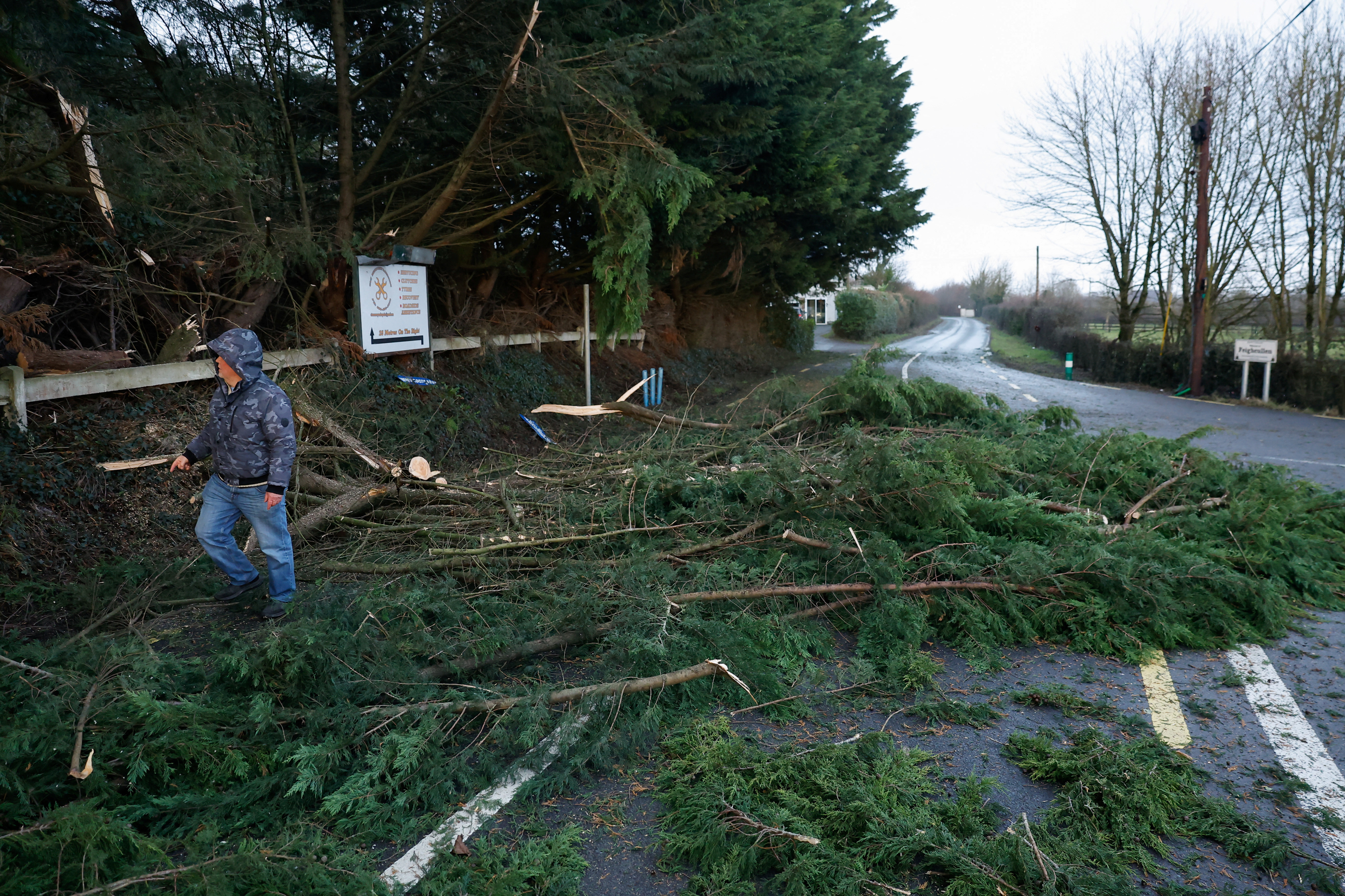 A person works to clear fallen trees from the road during Storm Eowyn, a status red alert extreme weather warning according to the Irish meteorological service, in Feighcullen, Ireland, January 24, 2025. REUTERS/Clodagh Kilcoyne