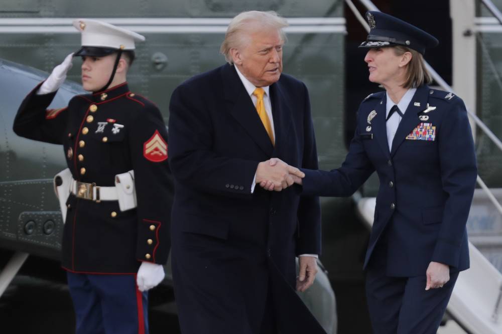 ترامب يستقبله قائد الجناح الجوي 89، قبل صعوده على متن طائرة الرئاسة (أ ب) 