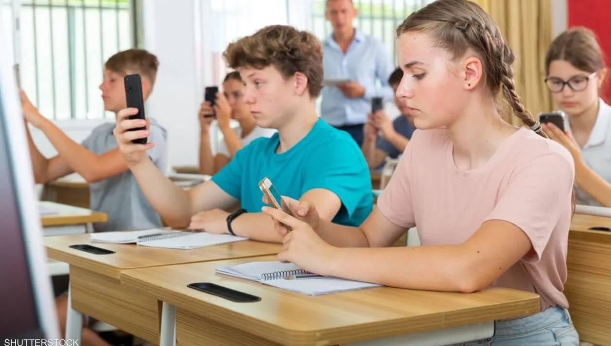 طلاب يستخدمون هواتفهم أثناء الحصص