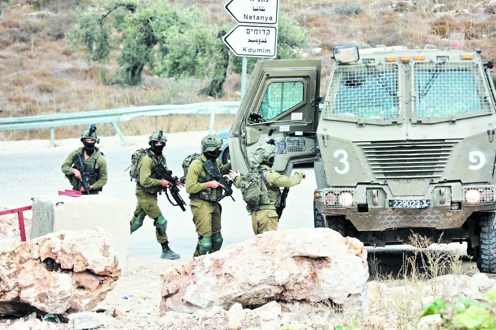 جنود إسرائيليون يقومون بدورية بالقرب من مدينة طولكرم بالضفة الغربية، ( اف ب)