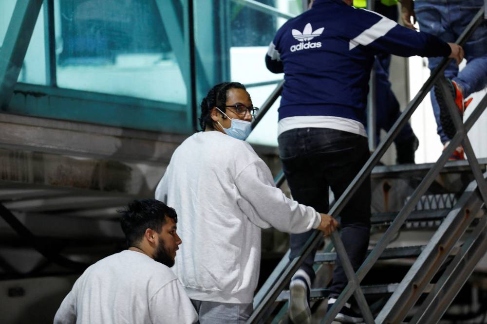 Venezuelan migrants climb a staircase following their arrival on a flight after being deported from the United States, in Caracas, Venezuela, March 24, 2025. REUTERS/Leonardo Fernandez Viloria