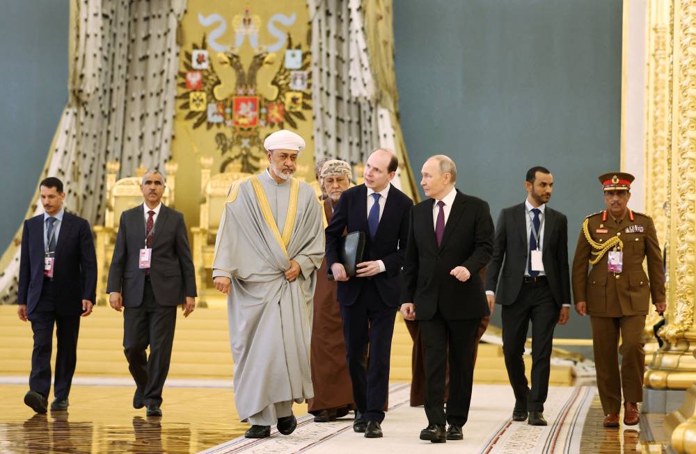 السلطان هيثم وبوتين ومسؤولون من البلدين في الكرملين (رويترز)