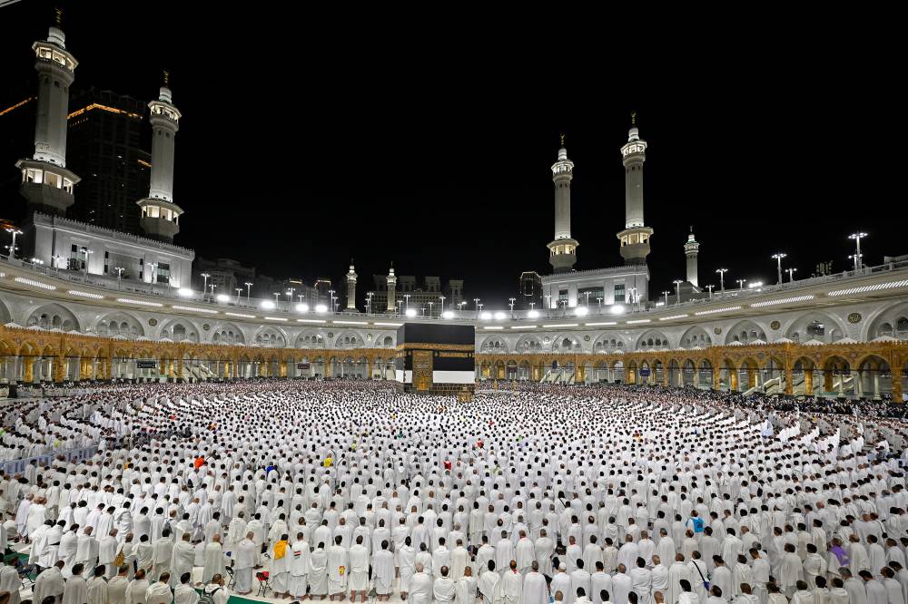 الحجاج يؤدون صلاة الفجر ليوم أمس في المسجد الحرام (رويترز)