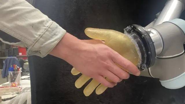 باحث يصافح يد روبوتية كسيت بالجلد الجديد