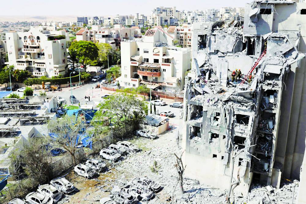 عمال الطوارئ يتفقدون الأضرار بمبنى جراء هجوم صاروخي إيراني في بئر السبع(أ ف ب )