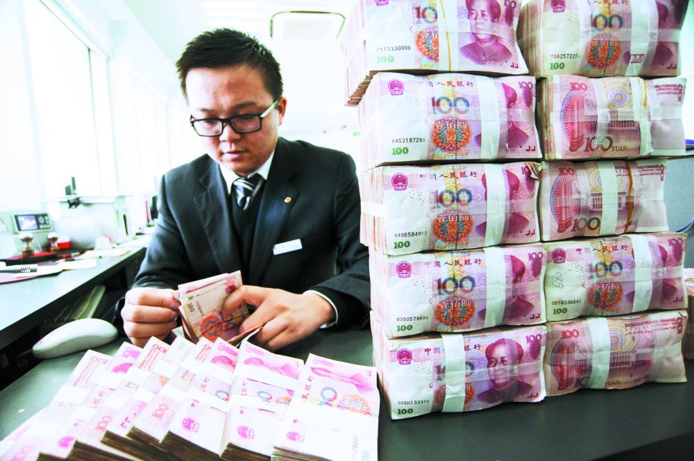 موظف يحسب الأوراق النقدية في فرع من بنك التعمير الصيني