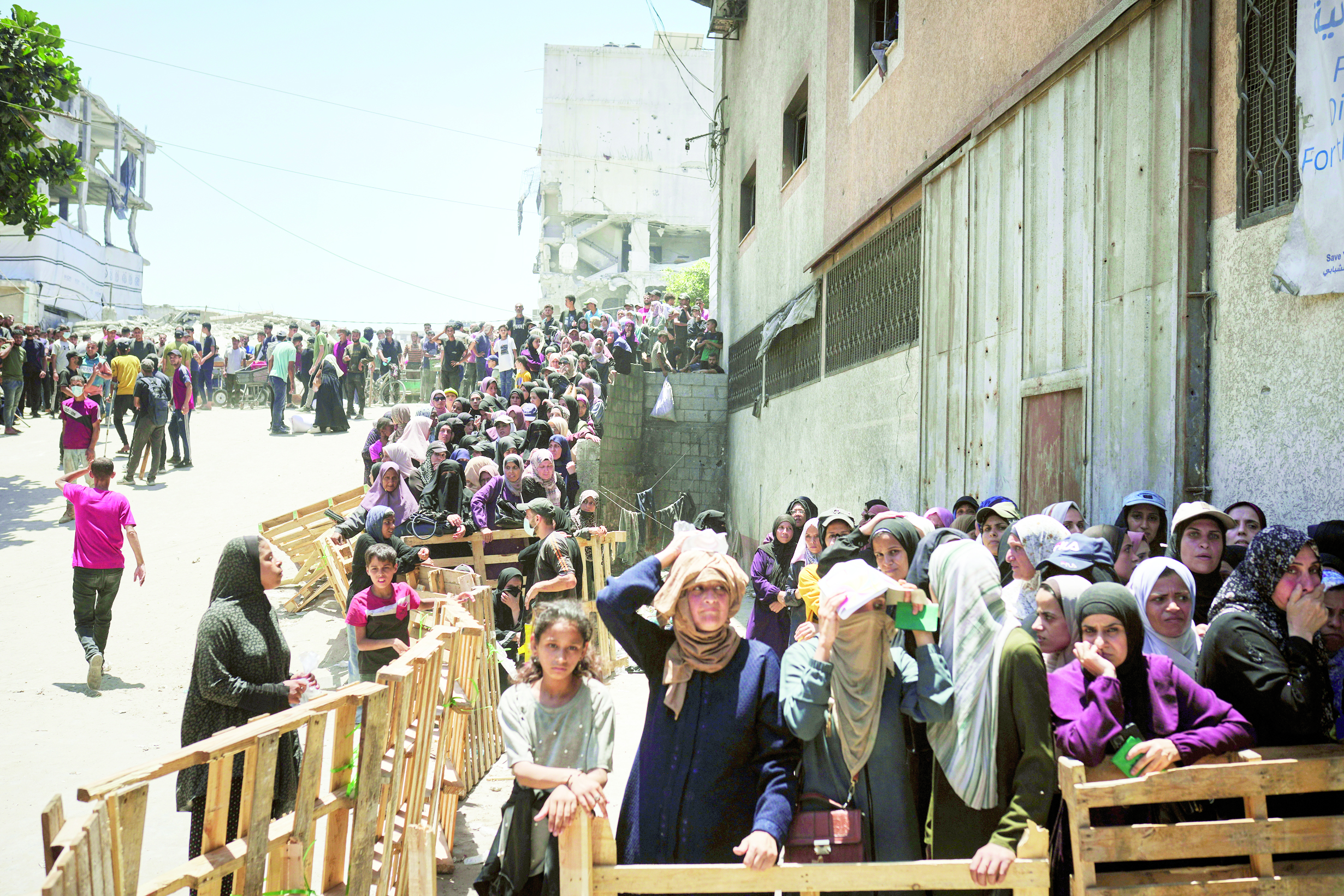 فلسطينيون يصطفون للحصول على أكياس الدقيق التي يوزعها برنامج الغذاء العالمي في مدينة غزة 