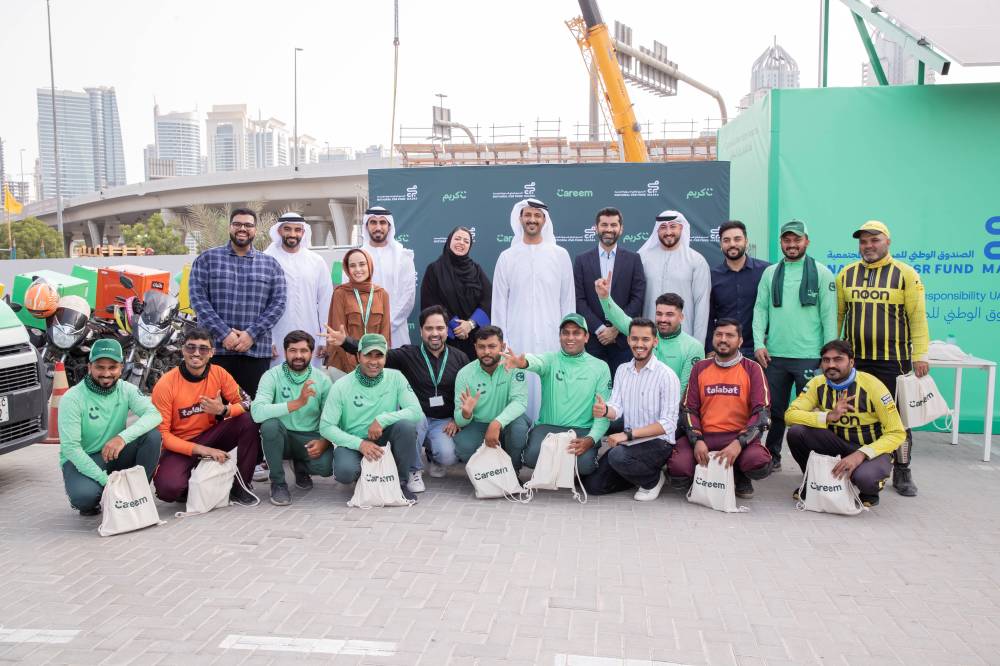 بن طوق مع عدد من سائقي التوصيل