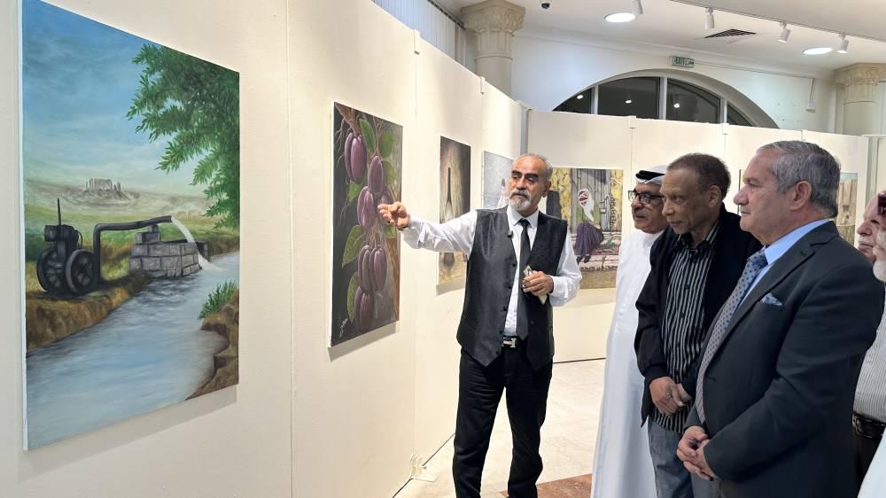  علي المغني وخليفة الشيمي يستمعان إلى شرح من الفنان عدنان الخشمان في معرض «إيقاعات فراتية»
