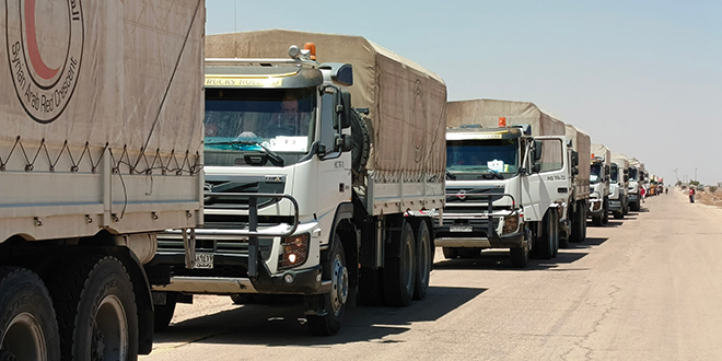 قافلة من الشاحنات تحمل مساعدات غذائية لدى دخولها مدينة السويداء