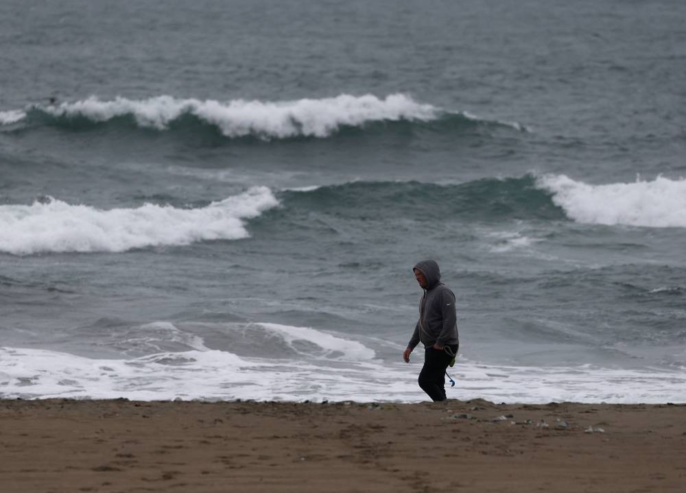 SAN FRANCISCO, CALIFORNIA - JULY 30: A beachgoer walks on the beach during a tsunami advisory at Ocean Beach on July 30, 2025 in San Francisco, California. Authorities are warning people to stay away from beaches following a massive 8.8 earthquake on the east coast of Russia triggered a tsunami warning for Hawaii and the west coast of the United States. No major damage has been reported. Justin Sullivan/Getty Images/AFP (Photo by JUSTIN SULLIVAN / GETTY IMAGES NORTH AMERICA / Getty Images via AFP)