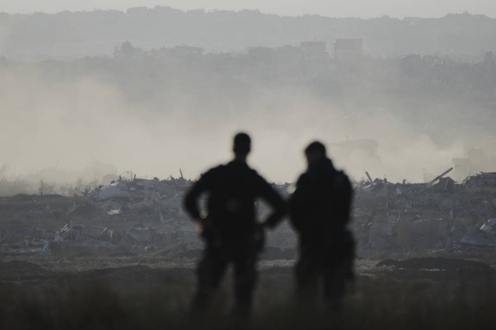 Israeli policemen watch the northern Gaza Strip as right-wing activists attend a rally calling for the re-establishment of Jewish settlements in the Gaza Strip, near the border in southern Israel, Wednesday, July 30, 2025. (AP Photo/Ohad Zwigenberg)
