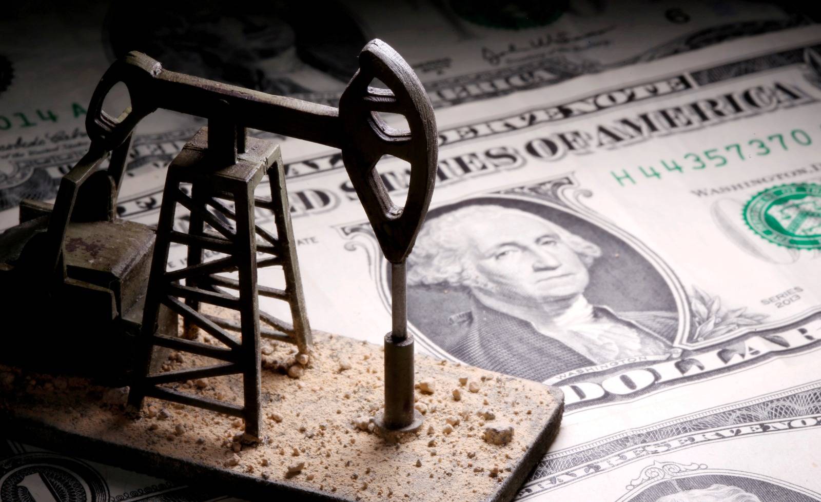 مضخة نفط على أوراق نقدية من الدولار 