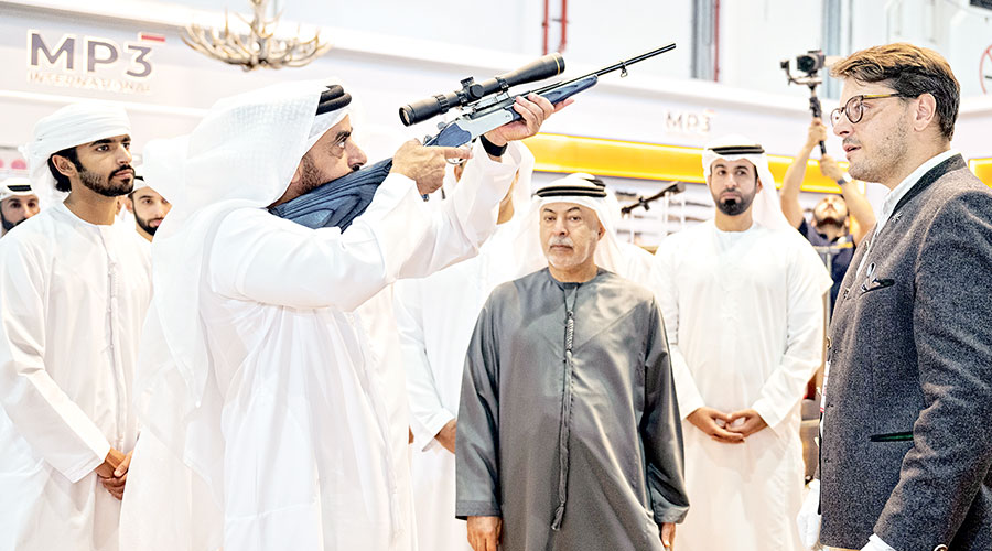 سيف بن زايد يتفقد بندقية خلال الزيارة 