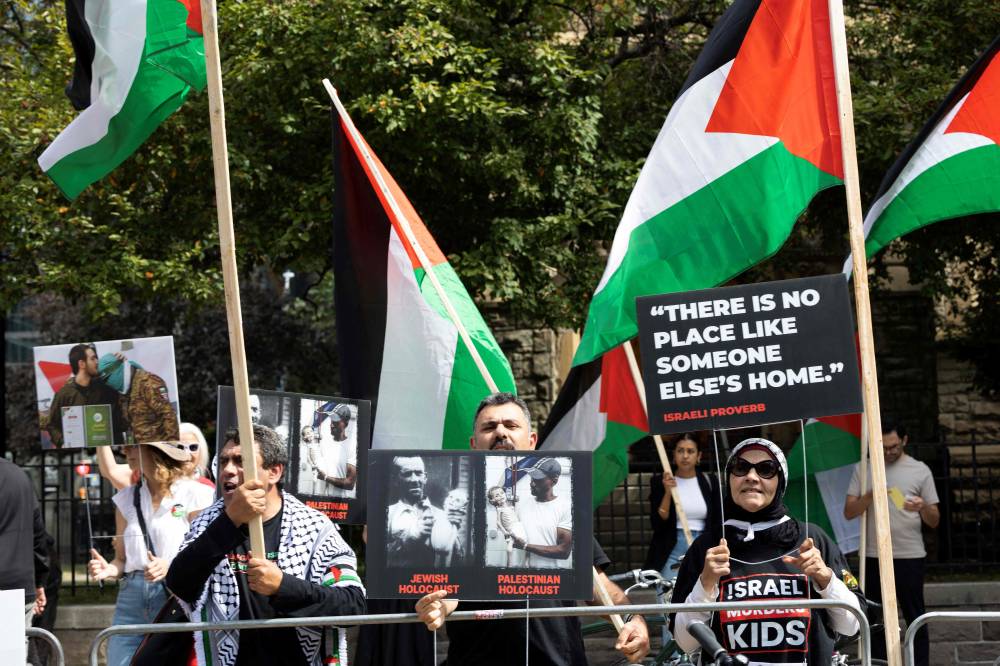 متظاهرون يلوحون بالأعلام الفلسطينية احتجاجاً على الفيلم الوثائقي “الطريق بيننا: الإنقاذ النهائي” (أ.ف.ب) 