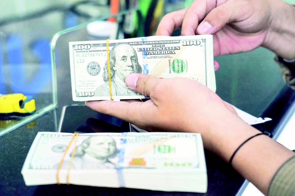 موظف يحسب أوراق الدولار الأمريكي في محل صرافة بجاكرتا. إندونيسيا ( أ ب)
