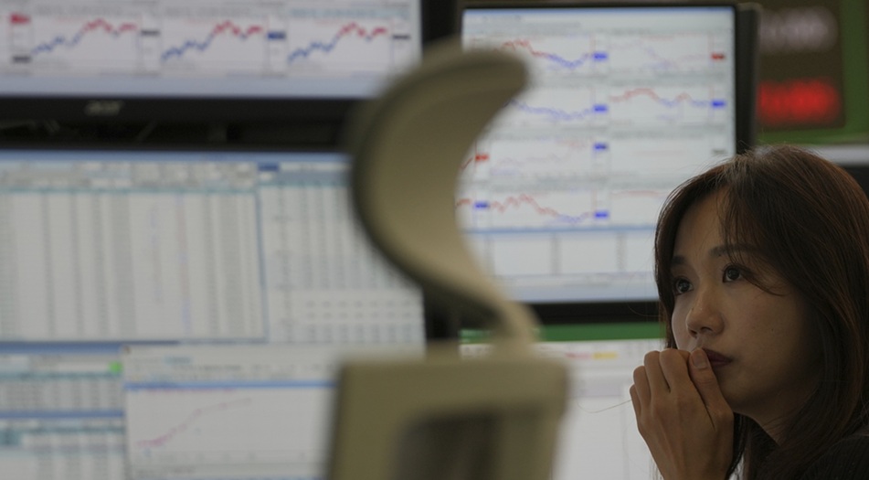 تطالع شاشة الأسعار في بورصة سيول (أ.ب)