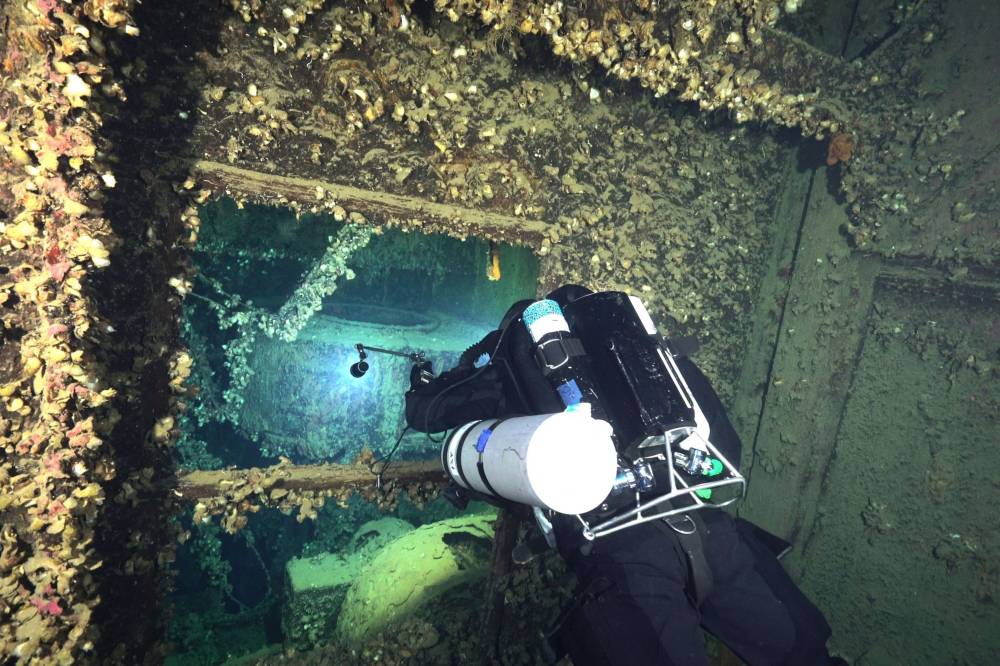 غواص يتجول بين حطام السفينة (أ.ف.ب)