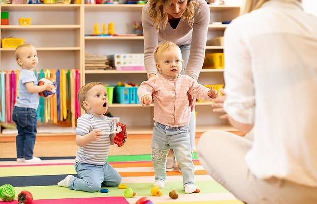 معلمتان تعتنينان بأطفال في حضانة